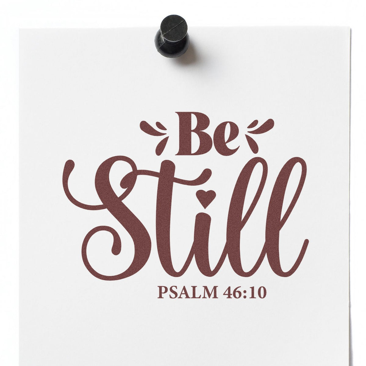 Black stamp seal on white paper with maroon Be Still lettering and Psalm 46:10.