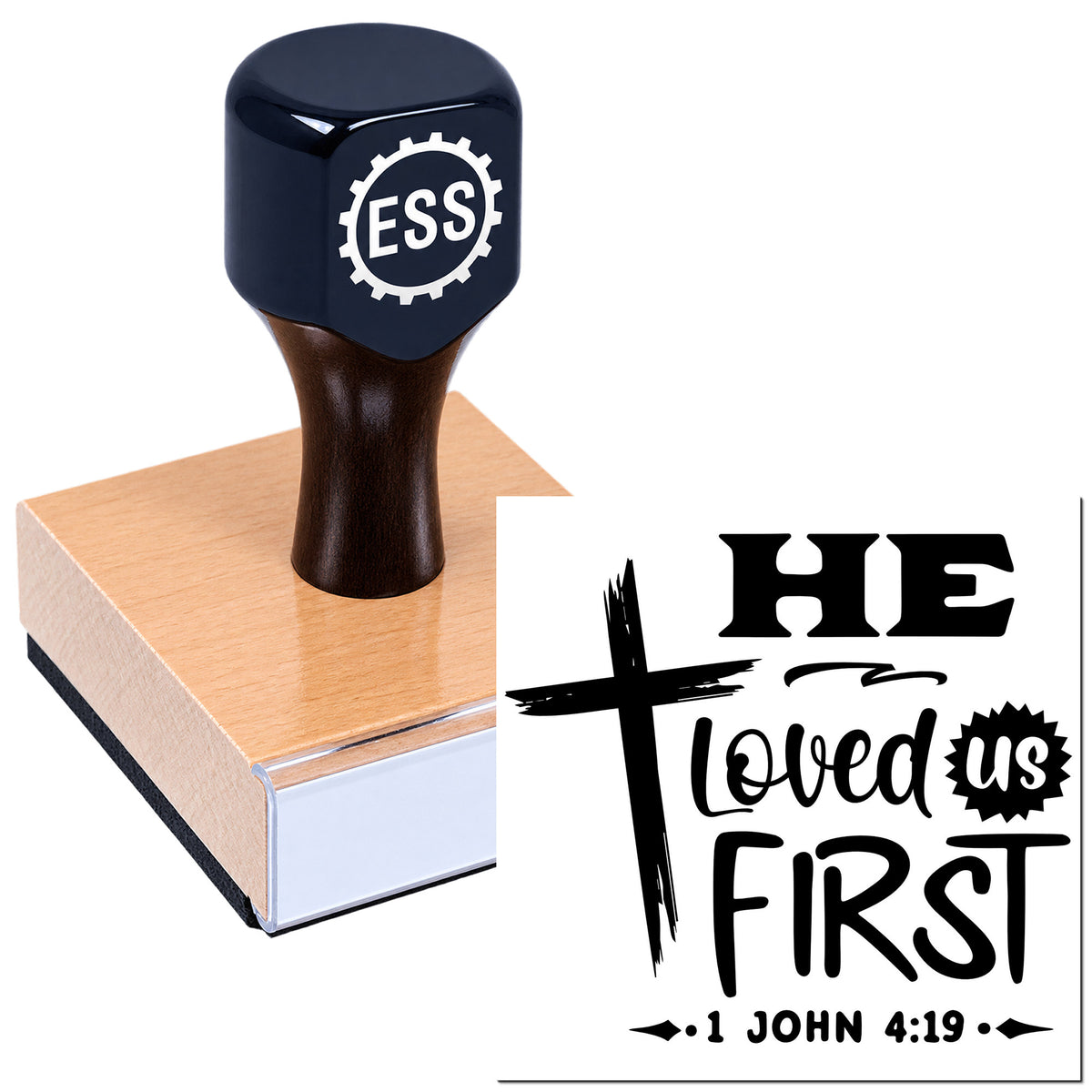Dark blue custom stamp and seal on a wood block, imprinting "He Loved Us First" in black with 1 John 4:19.