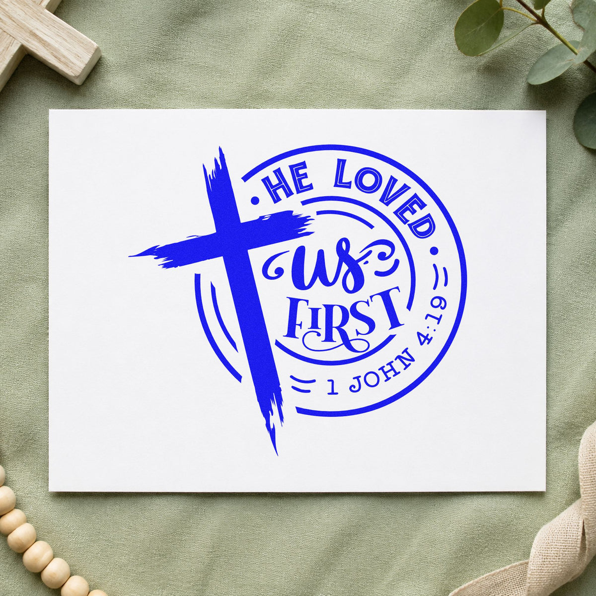 He Loved Us First Badge craft stamp in blue ink on cardstock, an easy option for canvas totes.