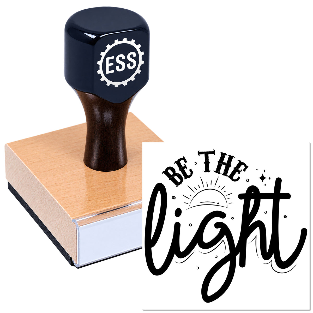 Dark blue ESS stamp and seal on a wooden block, printing a black "Be the light" design with sunburst accents.