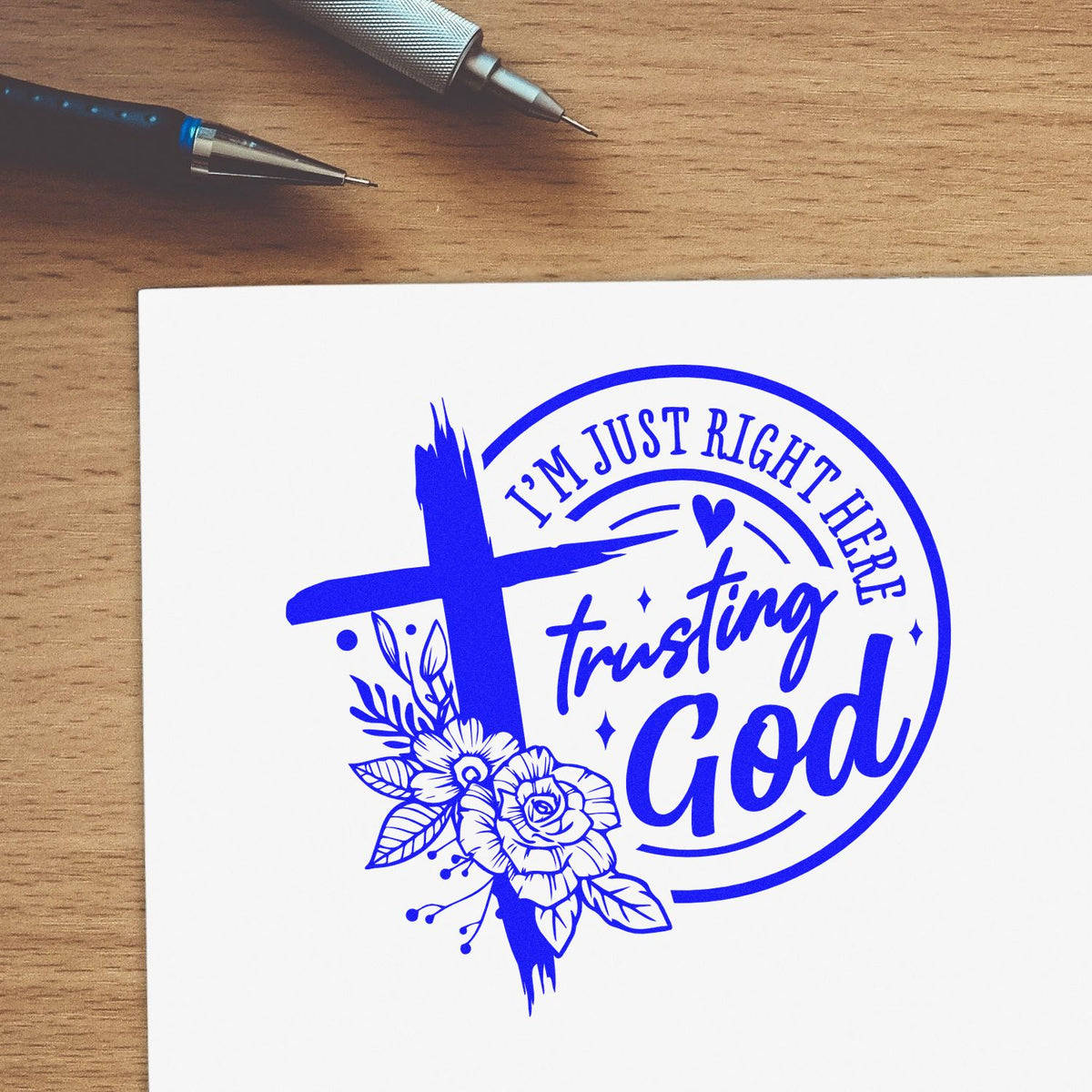 Blue custom rubber stamp and seal design with cross, flowers, and Im just right here trusting God on white paper.
