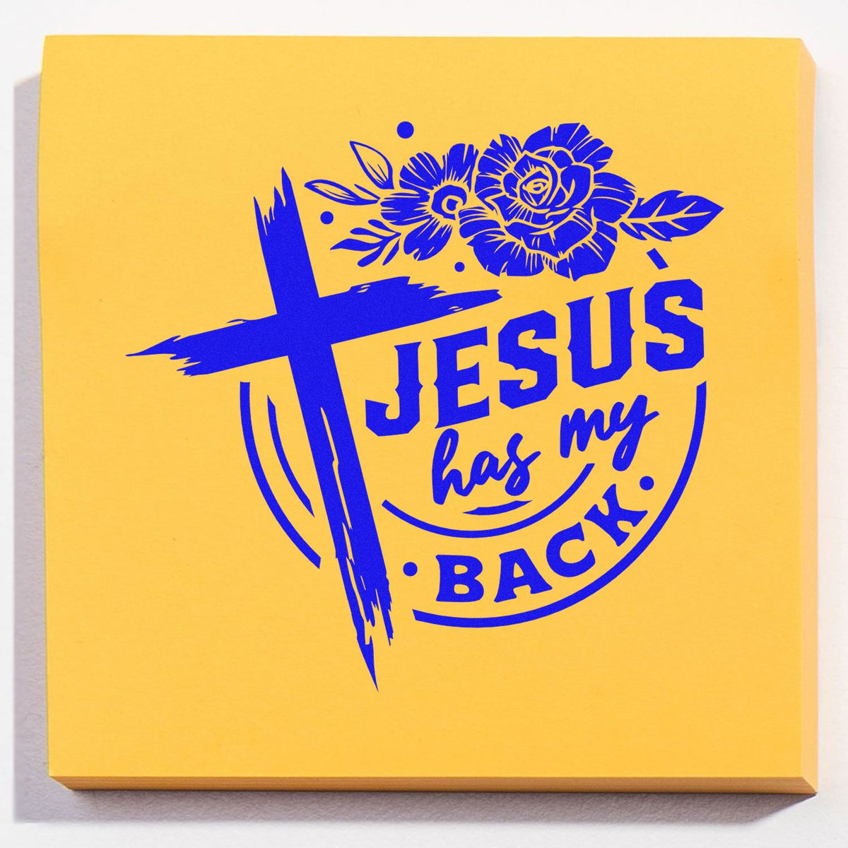 Yellow stamp and seal pad with blue Jesus has my back cross, floral design, and bold lettering.
