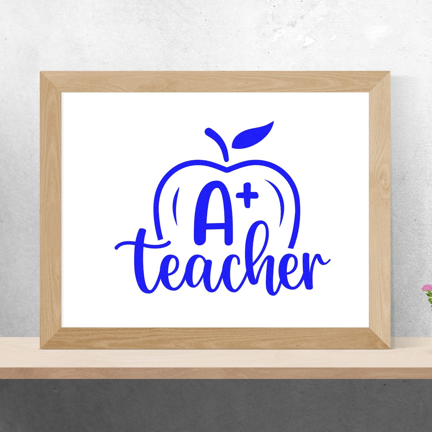 Blue A+ teacher apple stamp and seal design on white, framed in light wood, with bold classroom-style lettering and icon.