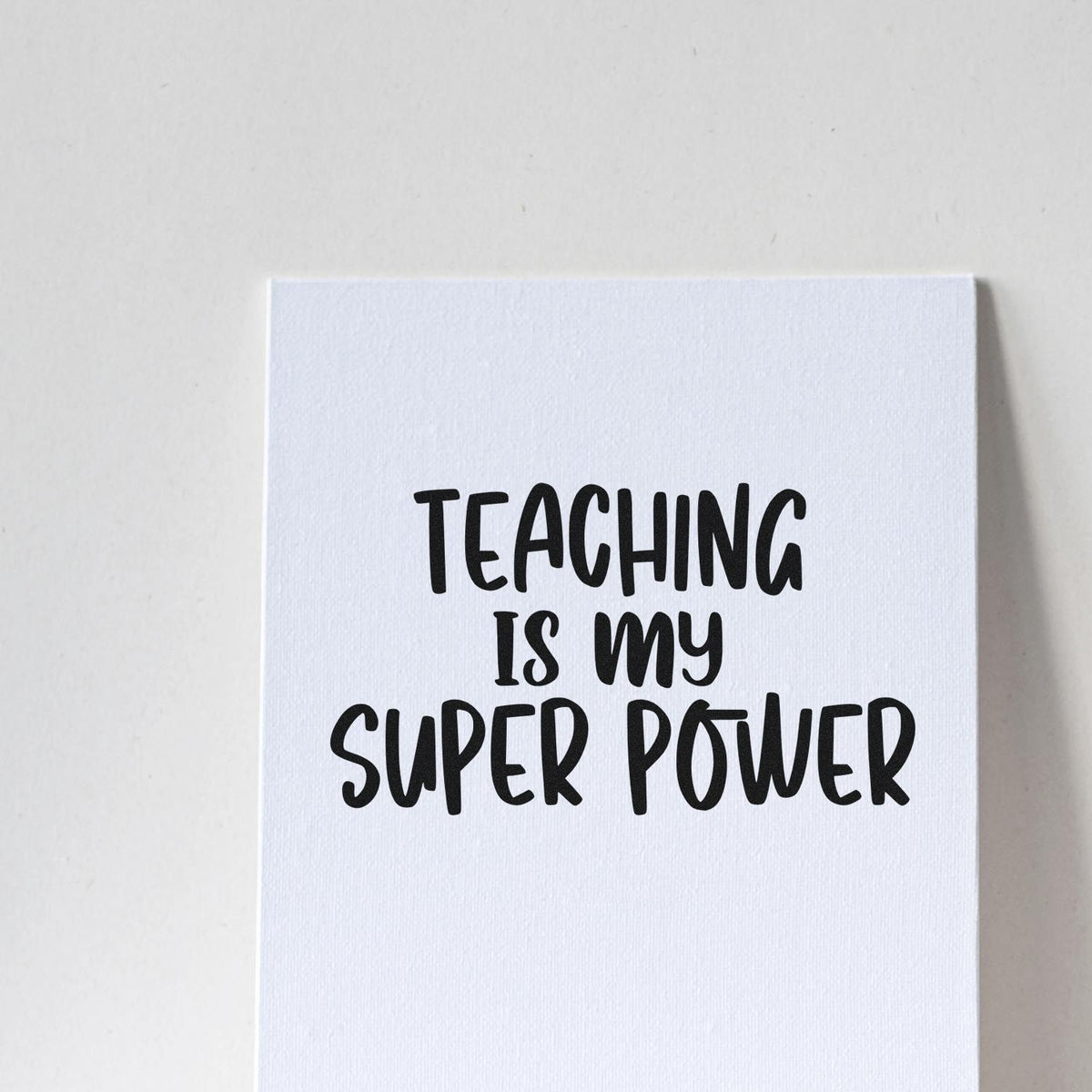 Black teacher stamp reading Teaching is my super power on a white textured card