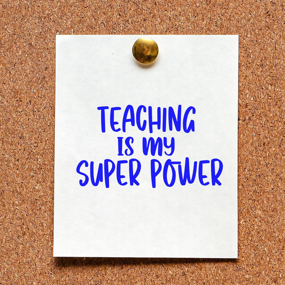 Teacher rubber stamp and seal with blue Teaching Is My Super Power on a white card pinned to a corkboard.