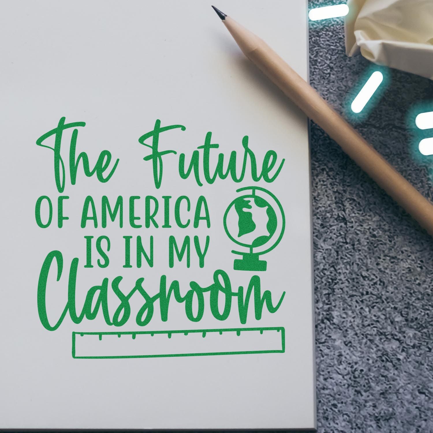 Green stamp and seal design reading The Future of America Is in My Classroom, with a globe icon, green text, and a pencil on white paper.