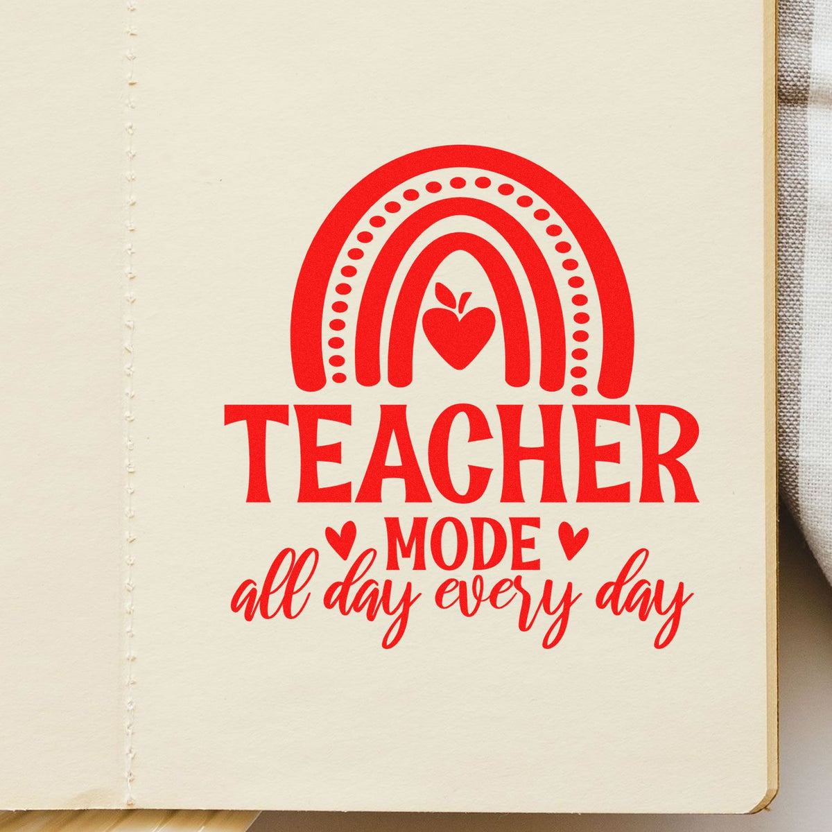 Red teacher-mode rubber stamp seal with rainbow heart and all day every day on cream notebook page