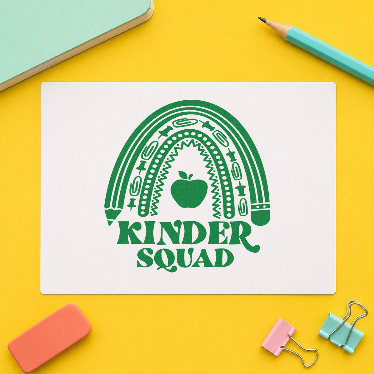 Kinder Squad Rainbow Apple craft stamp imprint in green ink on a handmade project, one idea being phonics chart pages.