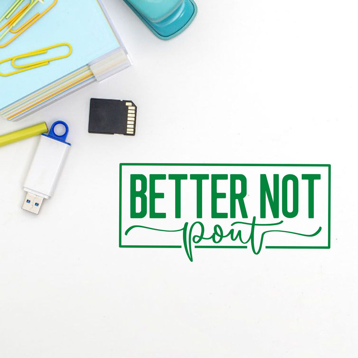 Green Better Not Point stamp seal with paper clips, USB drive, SD card, and teal office supplies on white background.