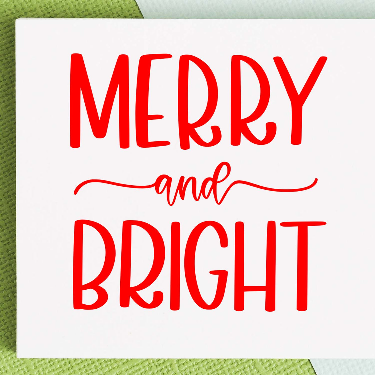 Red Merry and Bright stamp and seal design on white card with green background and script swashes.