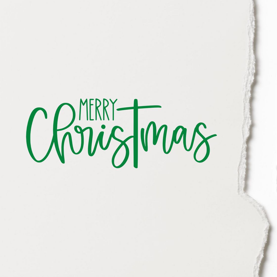 Green Merry Christmas stamp seal design on white textured paper with torn edge.