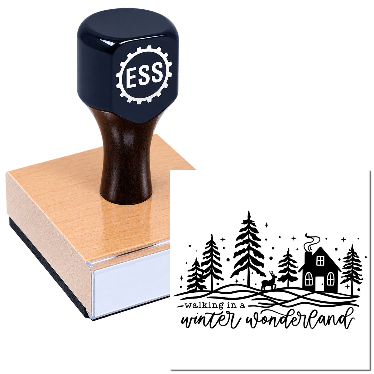 Dark blue ESS stamp and seal on a wooden block, showing a black winter wonderland design with trees, cabin and deer.