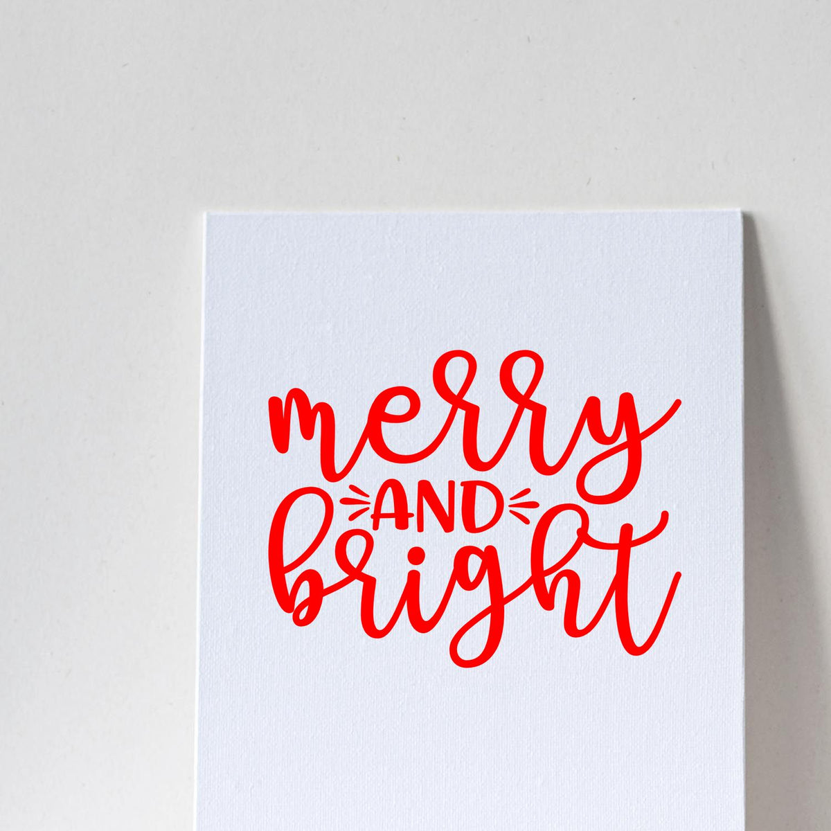Red Merry and Bright stamp and seal design on white textured card, festive red calligraphy.
