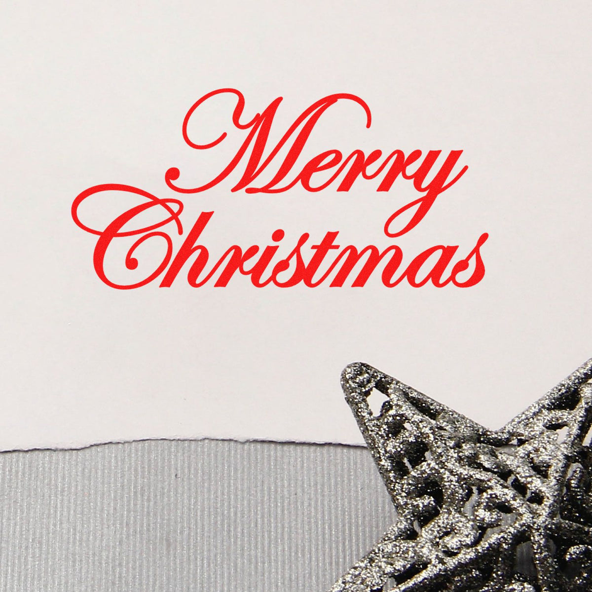 Red Merry Christmas script stamp on white paper, paired with a silver glitter star seal.