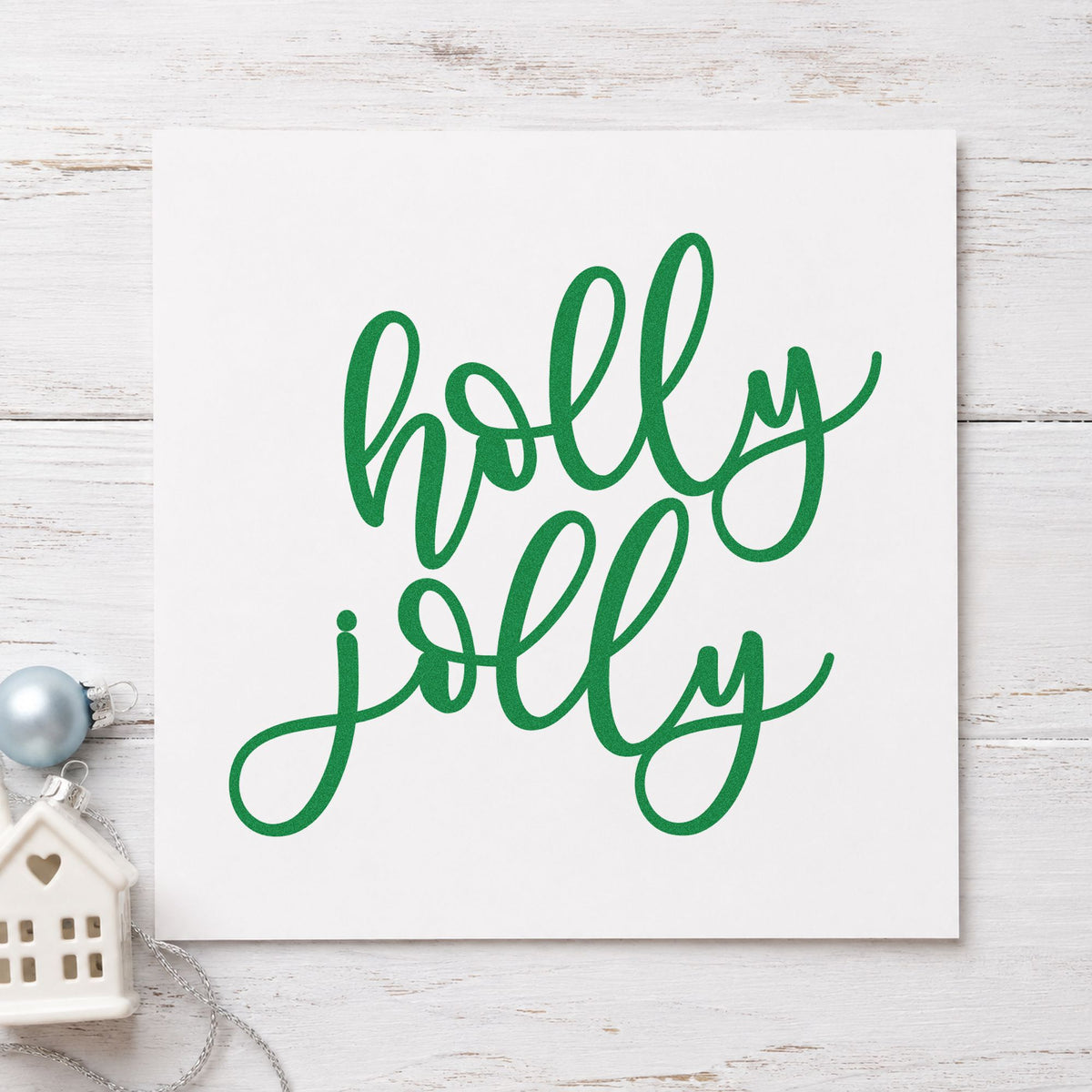 Holly Jolly Script craft stamp imprinted in green ink on paper, a design suited to framed bar cart.