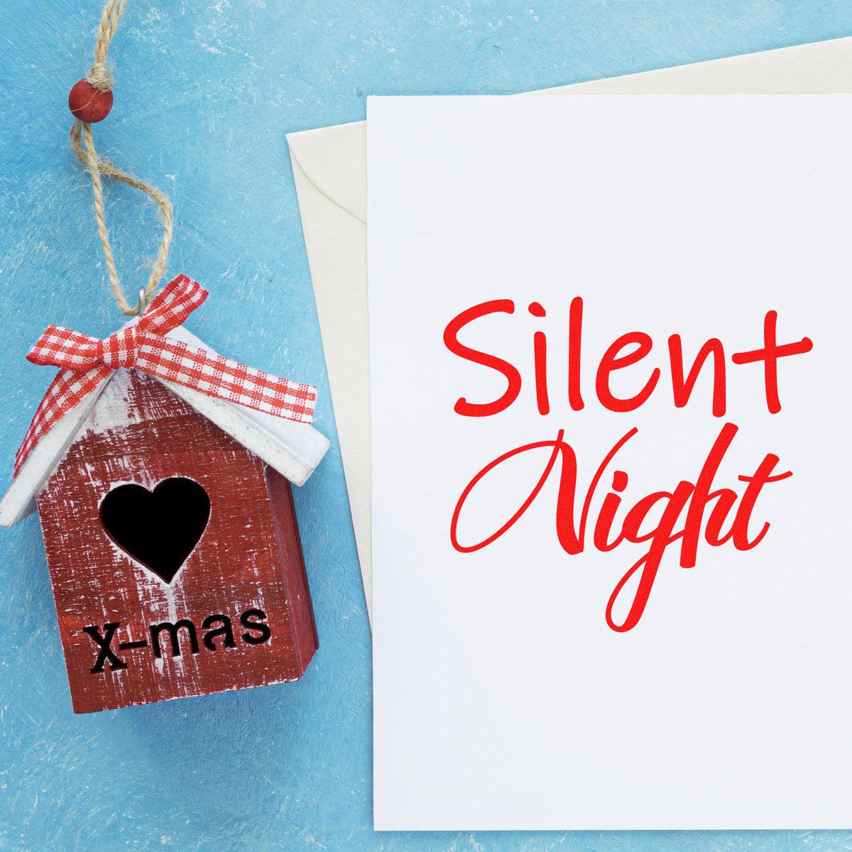 Holiday stamp and seal products featuring a red wooden house ornament with heart and a white Silent Night card on blue background.