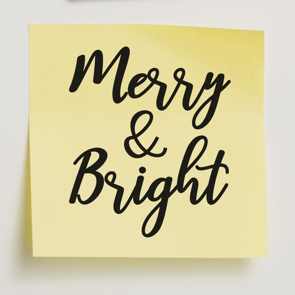 Yellow stamp and seal with black cursive Merry & Bright lettering for holiday packaging.