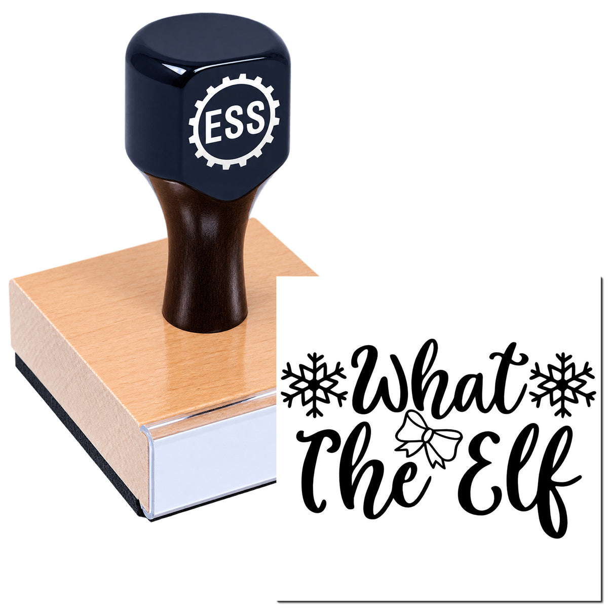 Dark navy ESS rubber stamp with wooden handle on pink base, beside black "What the Elf" holiday seal with snowflakes and bow.