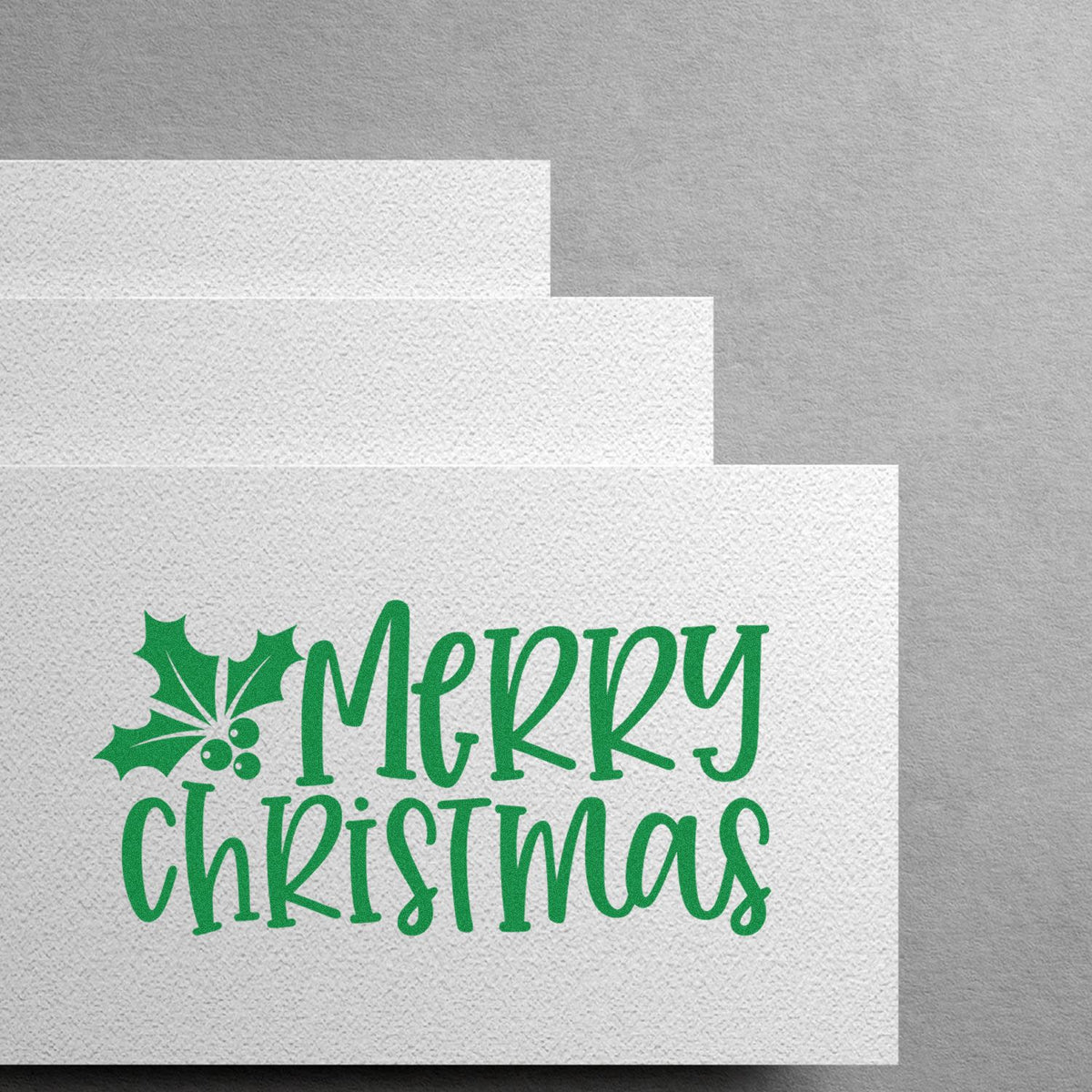 Green Merry Christmas stamp and holly seal on white textured paper cards