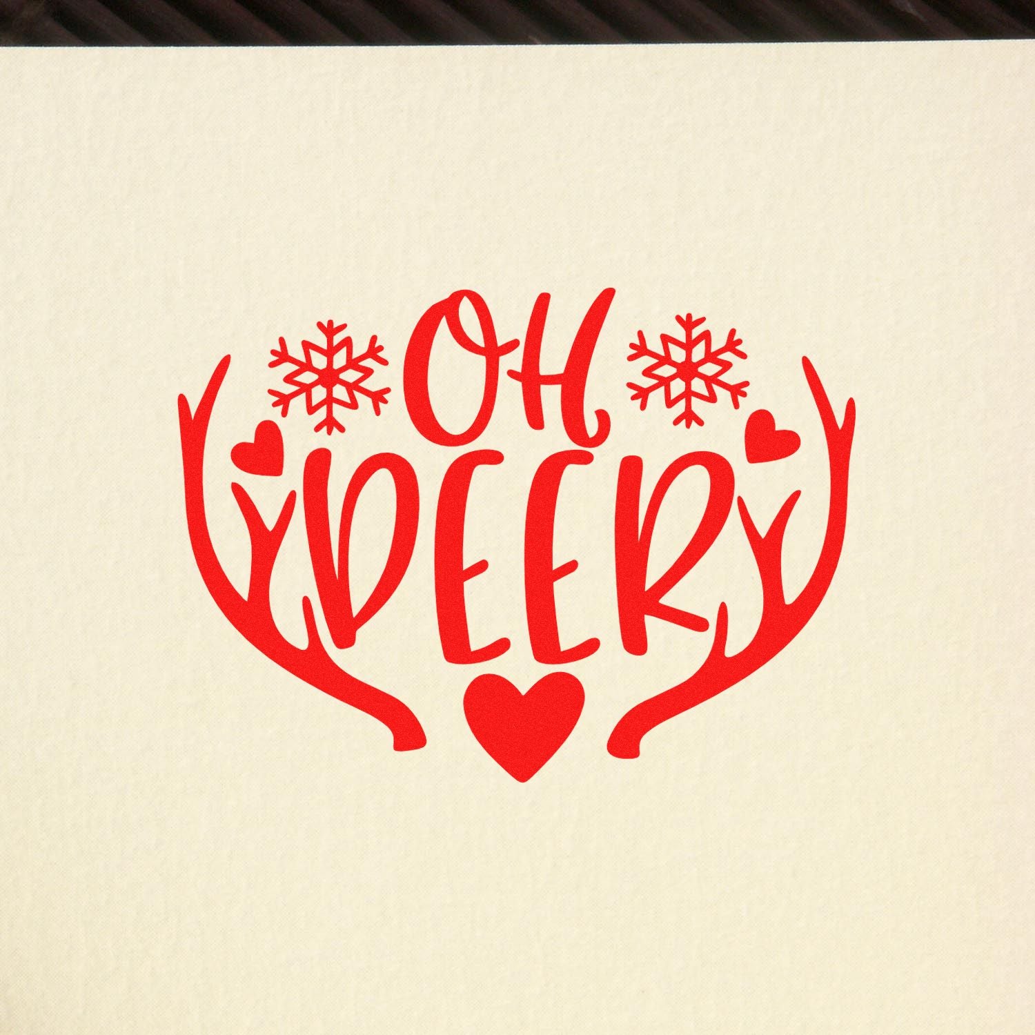 Red Oh Deer holiday stamp design with antlers, snowflakes, and hearts on a cream background.