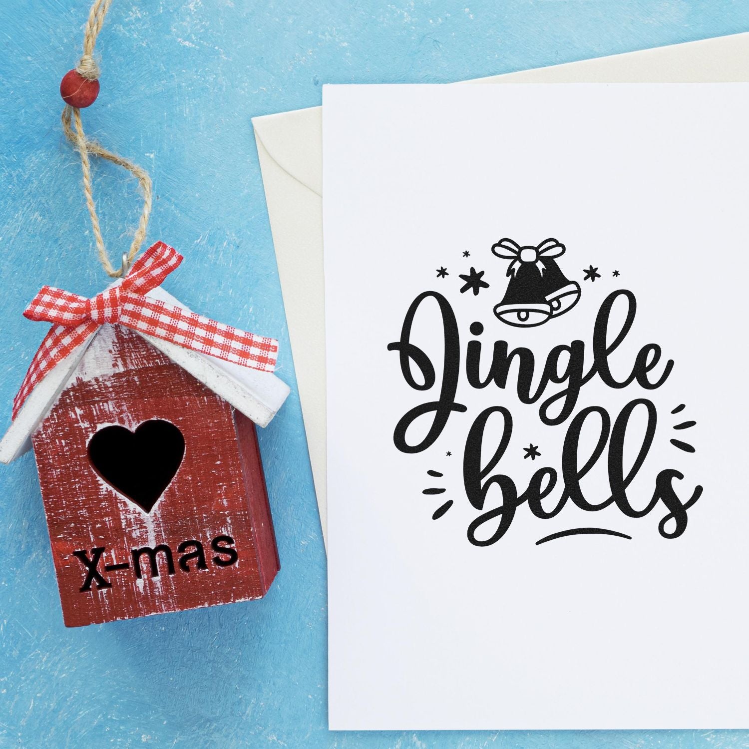 Rustic red birdhouse and holiday stamp and seal products: black Jingle bells on white card, blue background