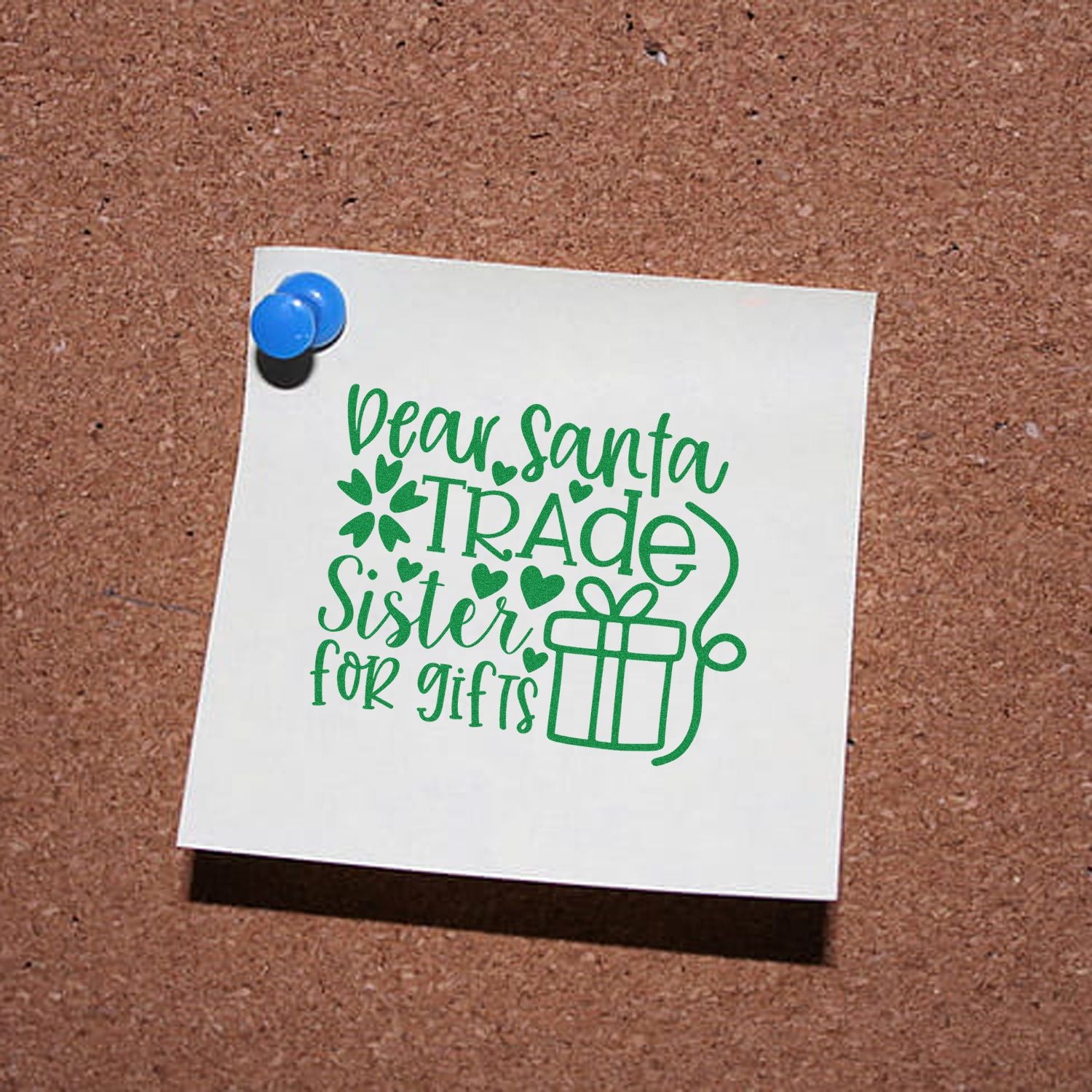 Green stamp-and-seal Christmas design on white card pinned to corkboard, reading Dear Santa, Trade Sister for gifts with gift icon.
