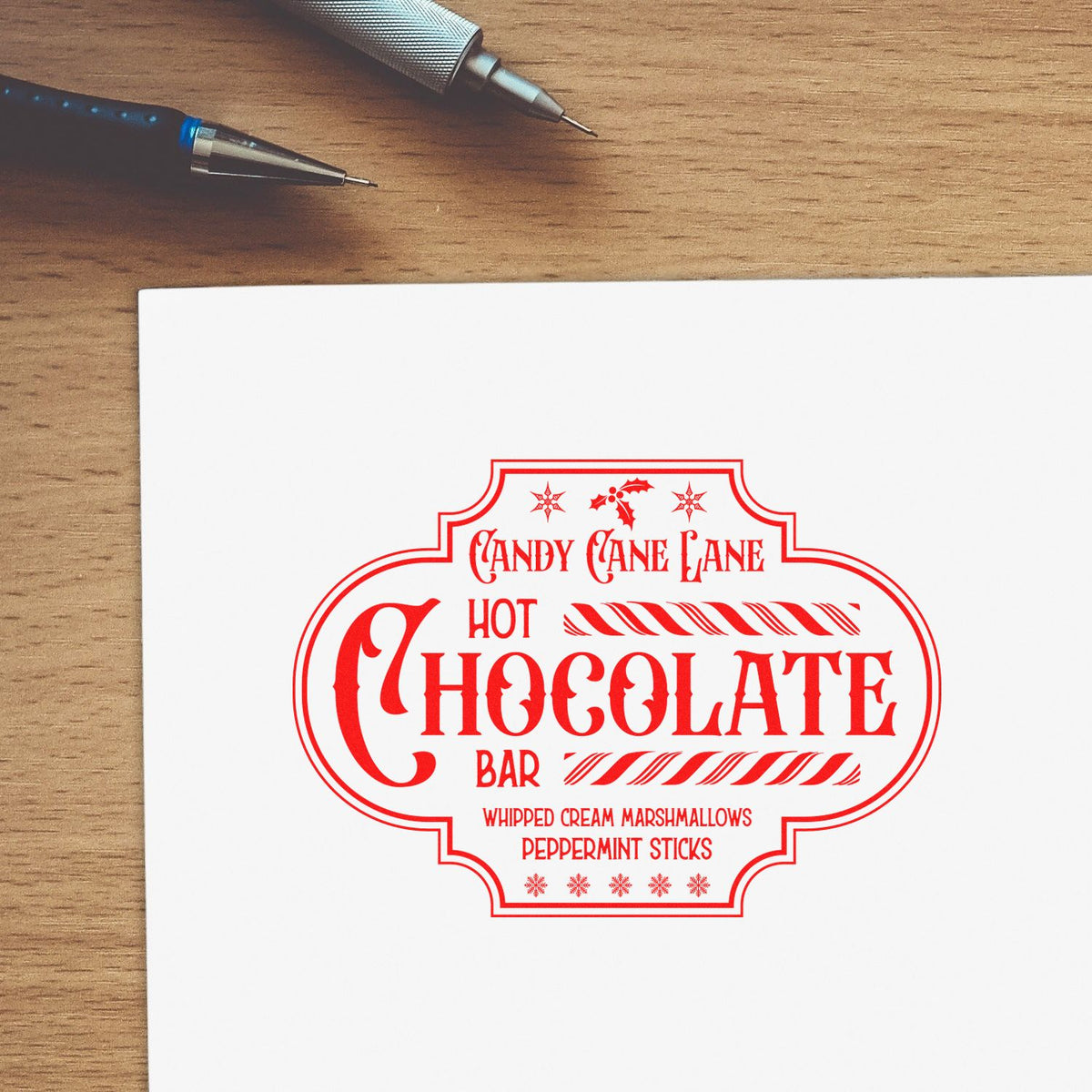 Red holiday stamp and seal design for a hot chocolate bar with candy cane, marshmallow and peppermint details on white paper.