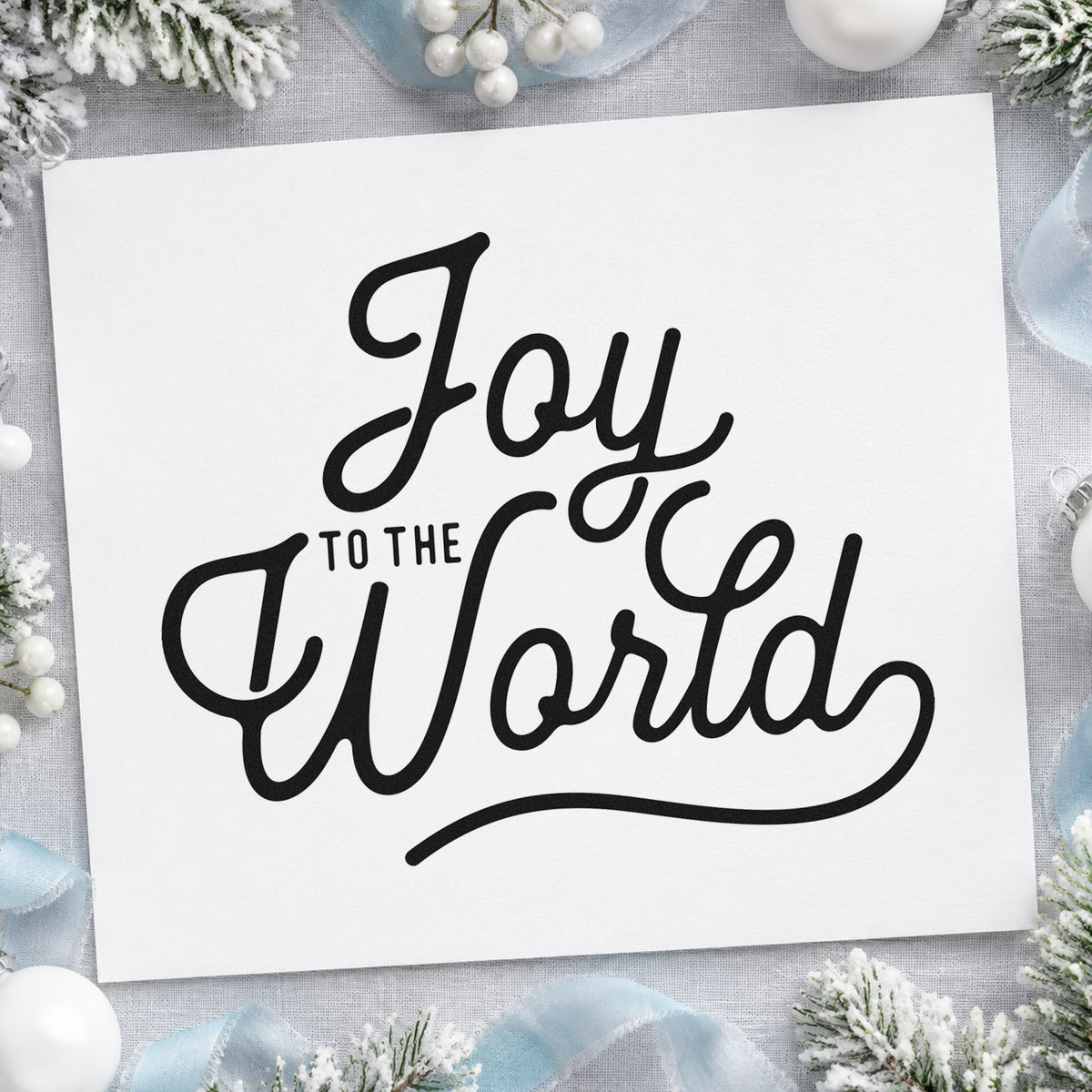 Joy To The World Script craft stamp imprint in black ink on a handmade project, one idea being large small tags.