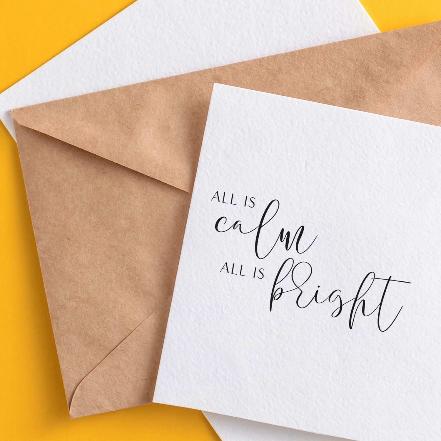 Stamp and seal products: kraft envelope and white card reading All is calm, all is bright on a bright yellow background.