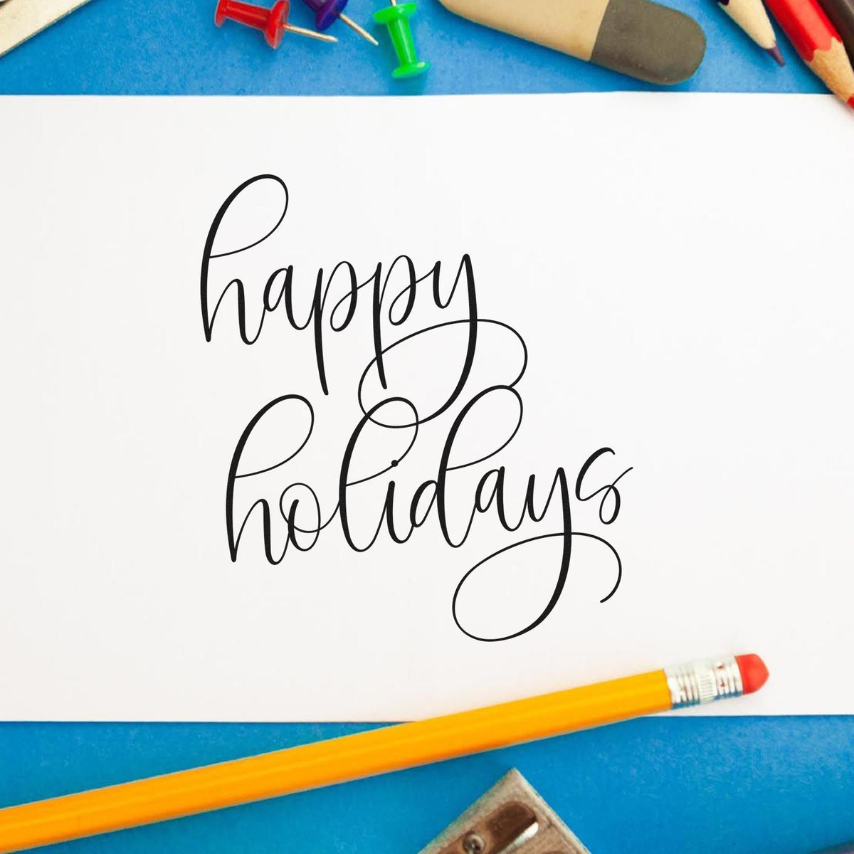 Vintage Pro Happy Holidays Flourished Calligraphy Premium Wooden Stamp imprint stamped in black ink. The words "happy holidays" appear in two lines of thin script with large looping flourishes.