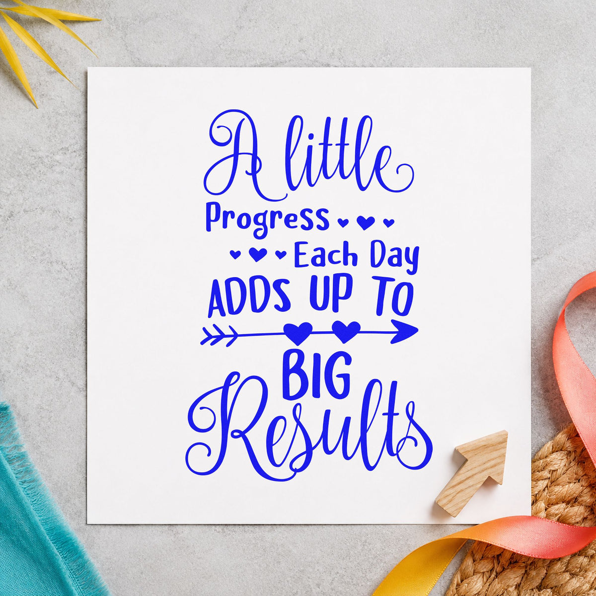 Little Progress Big Results craft stamp in blue ink on cardstock, an easy option for wristband printing.