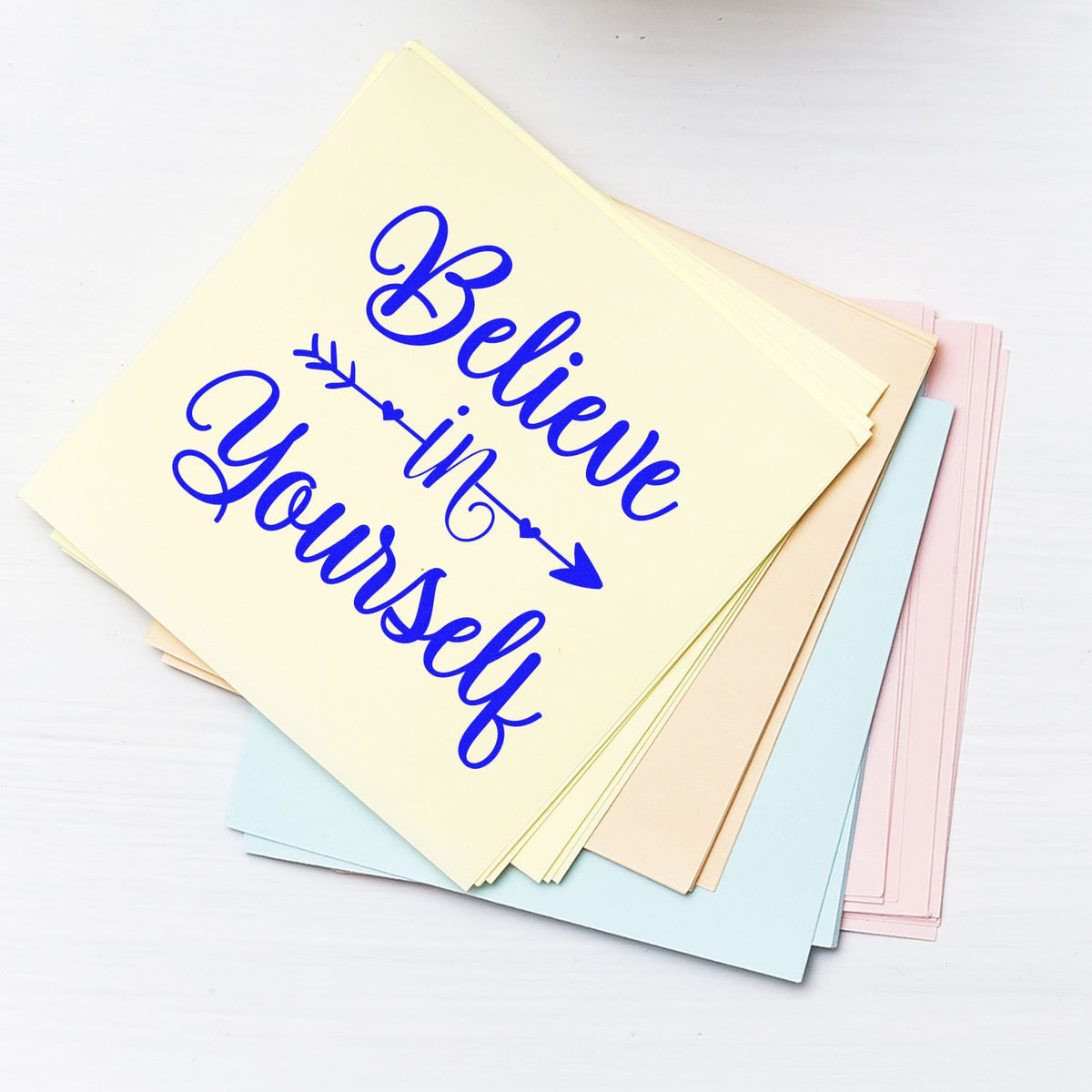 Pastel stamp and seal sheets with blue Believe in Yourself calligraphy and arrow design