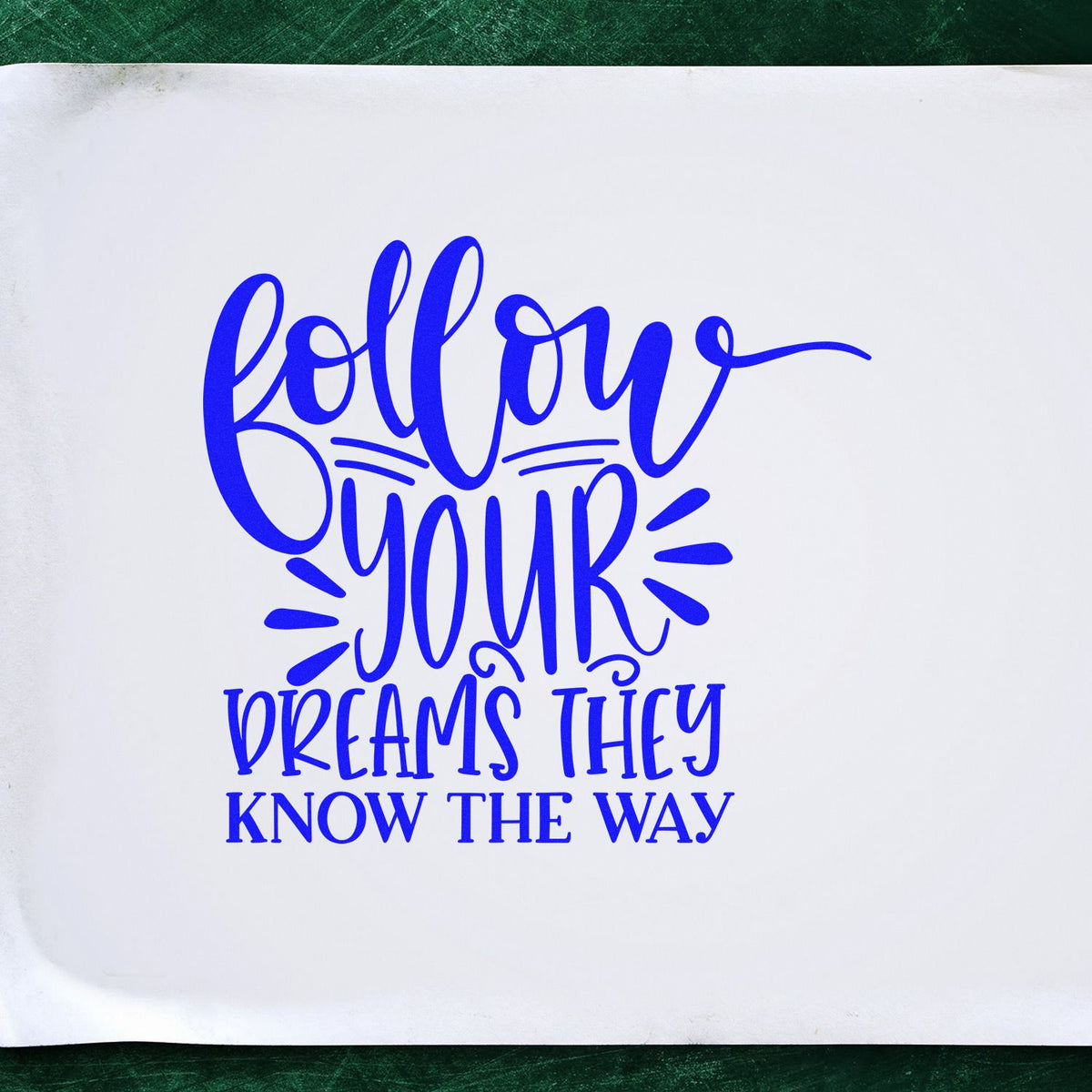Blue custom stamp and seal reading Follow your dreams, they know the way on white paper, with green background.