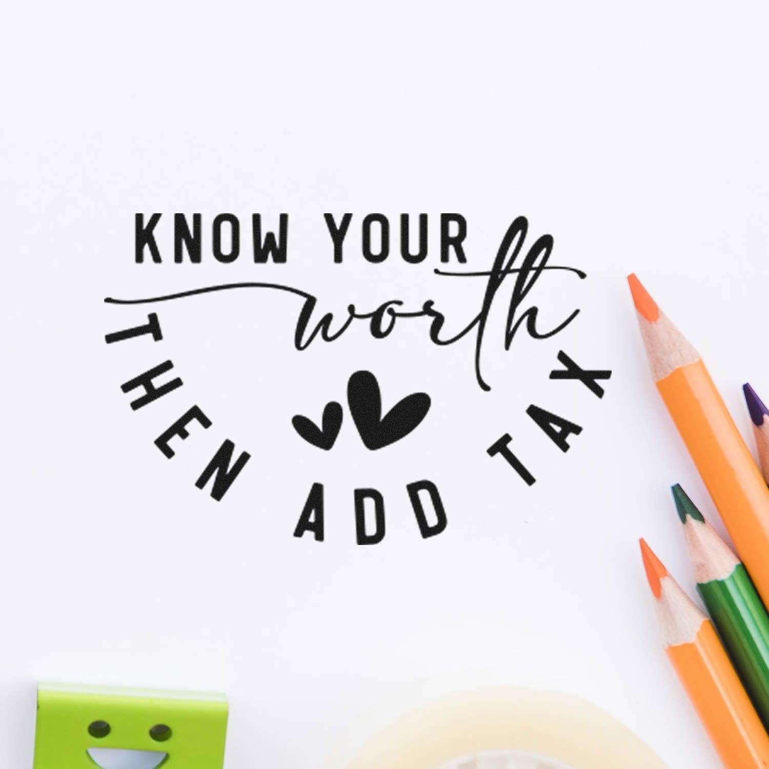 Black motivational stamp/seal reading Know your worth then add tax with hearts on white paper, beside colorful pencils.