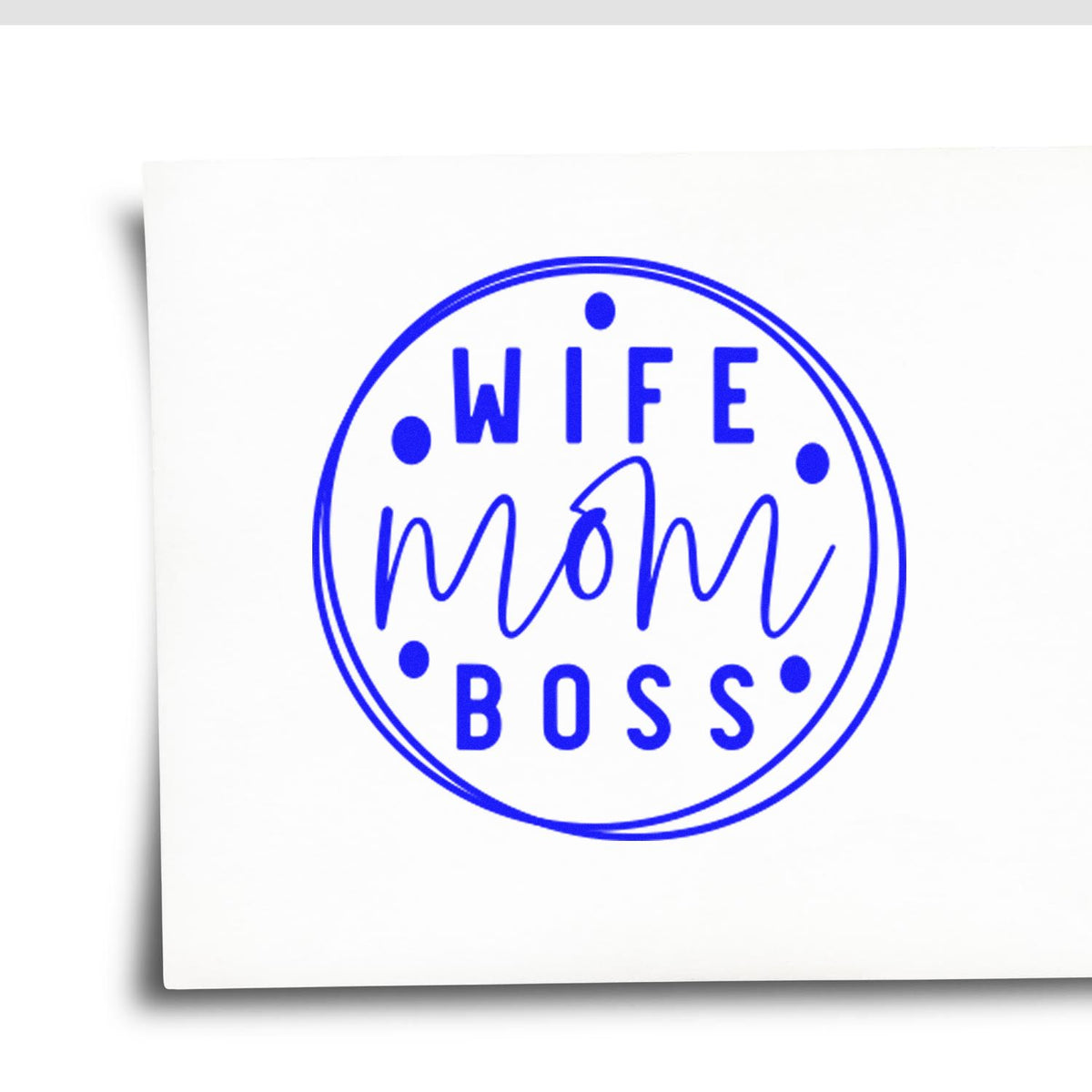 Blue circular self-inking stamp and seal reading WIFE MOM BOSS on white paper