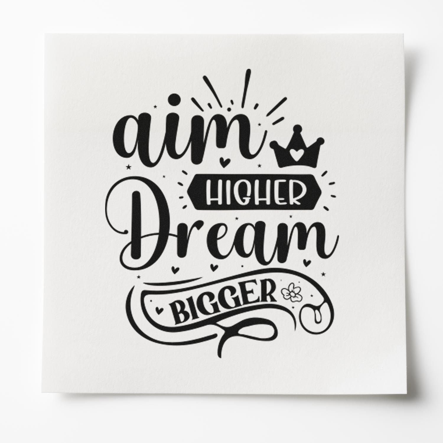 Black stamp and seal design reading Aim Higher, Dream Bigger with crown, hearts and decorative accents on white background.