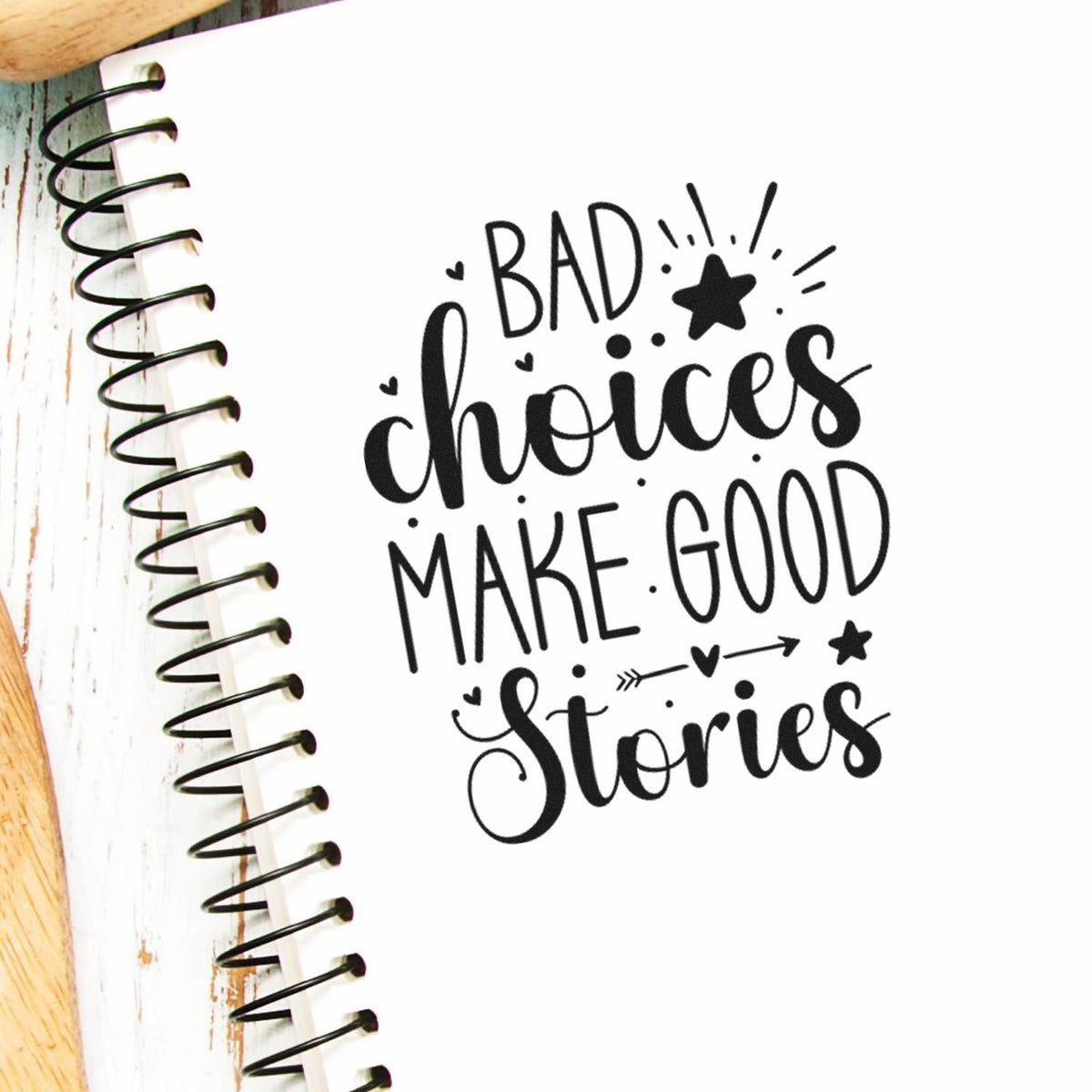 Bad Choices Make Good Stories Premium Wood-Mounted Stamp - Vintage Pro imprint stamped in black ink. The phrase "Bad choices make good stories" includes stars, a heart-detailed arrow, dots, and rays.