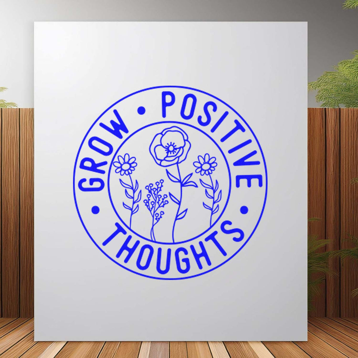 Blue circular rubber stamp seal with floral line art and text Grow Positive Thoughts on a white background.