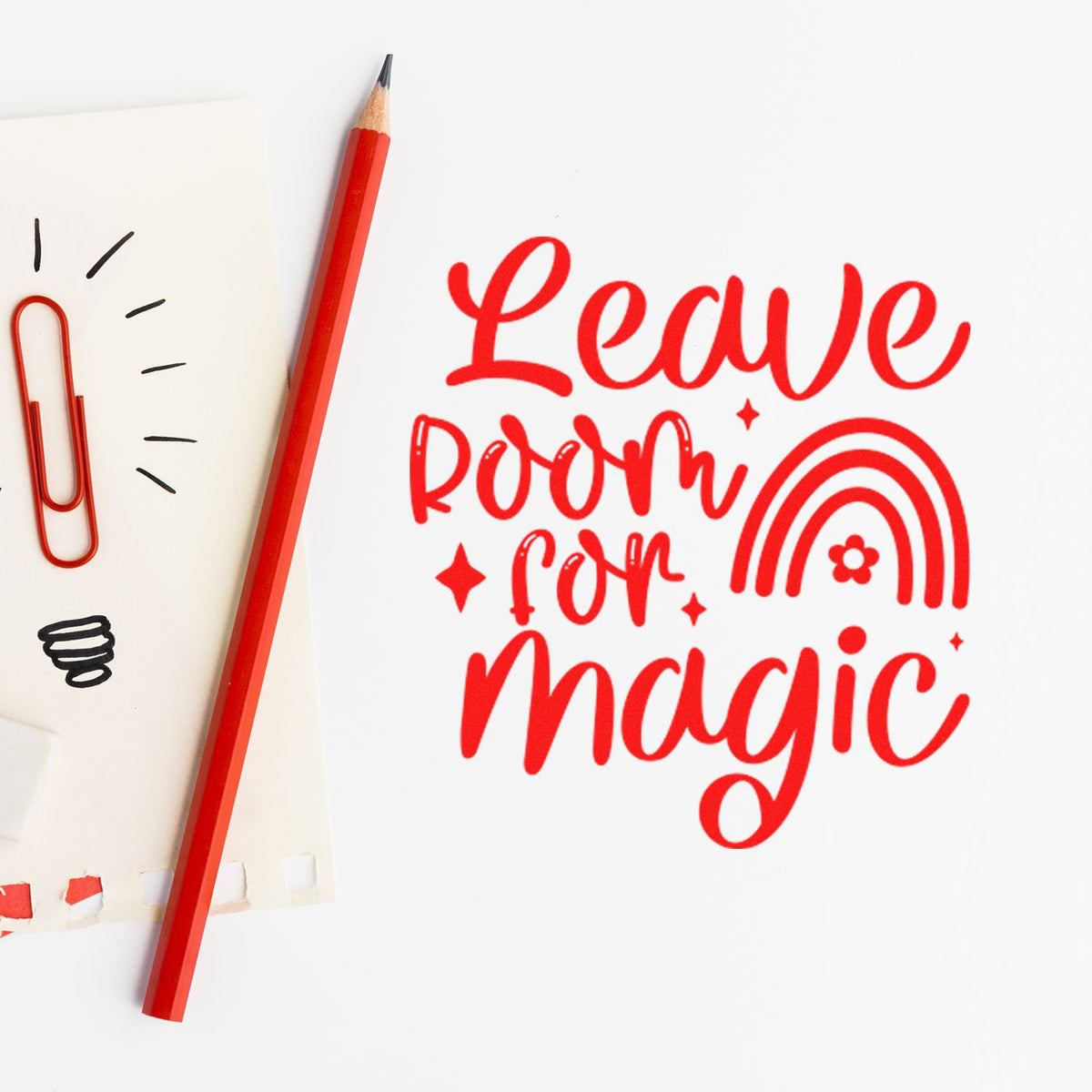 Red Leave Room for Magic stamp with rainbow seal, red pencil, and paper clips on white paper.