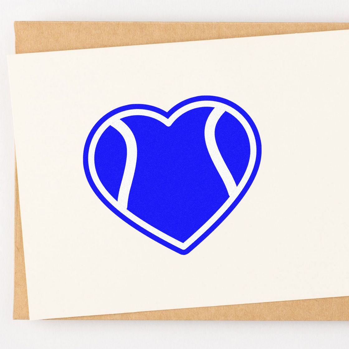Blue heart-shaped stamp seal on a white card over tan paper, with bold white accents.