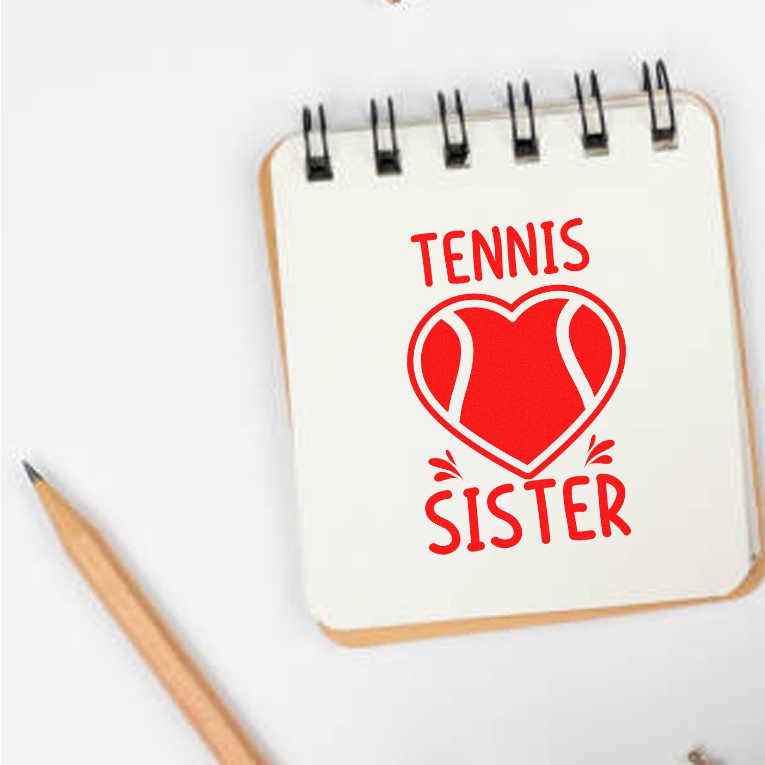 Red tennis sister stamp and seal design on cream spiral notebook, with heart motif and pencil.