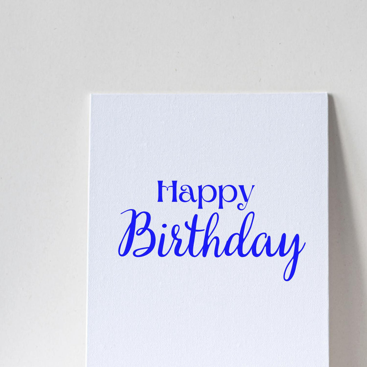 Blue Happy Birthday stamp on a white textured card for seal products