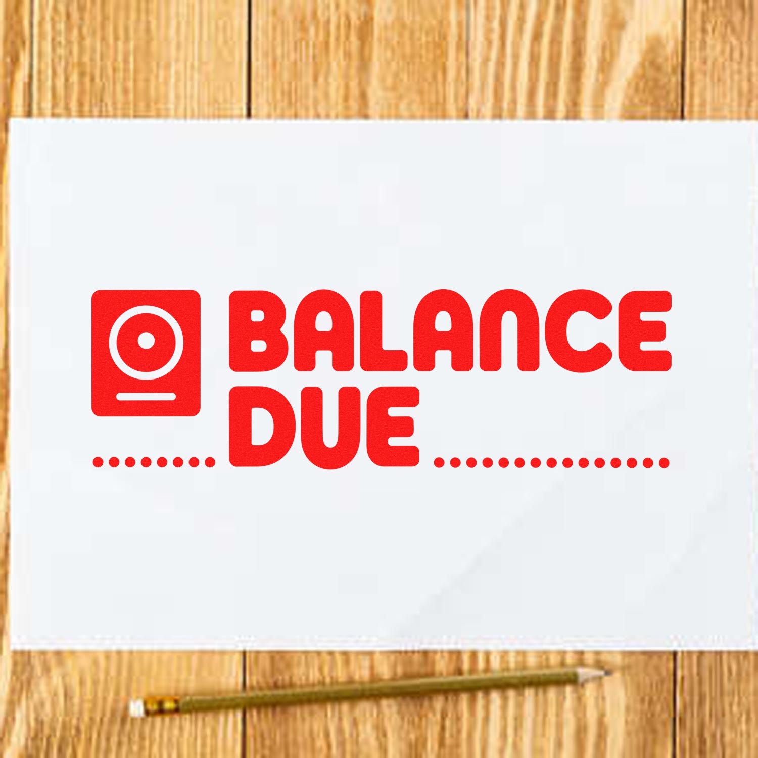 Red Balance Due stamp and seal on white paper, bold red text and icon on a wooden desk with a pencil.