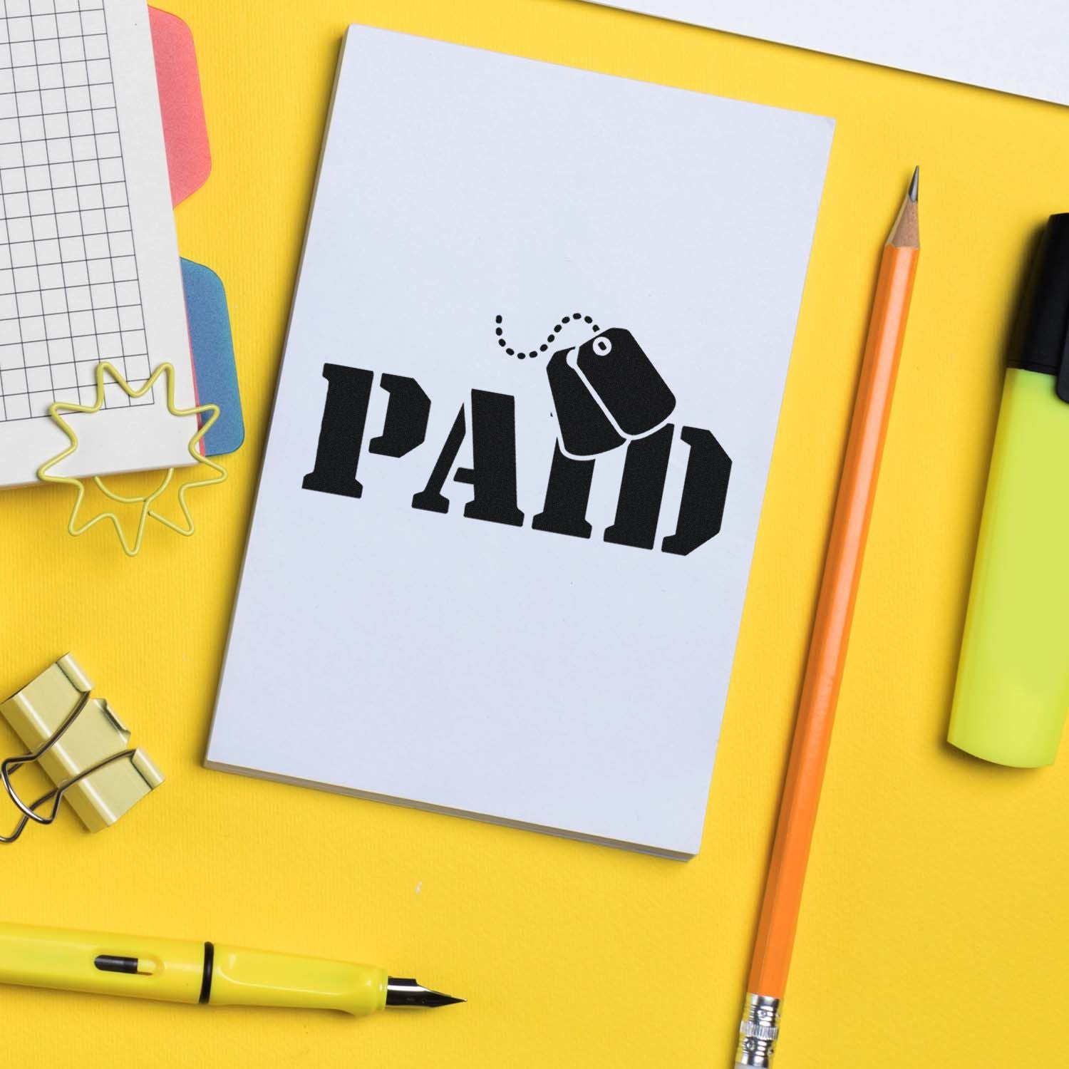 Black PAID stamp and seal design on white card, surrounded by yellow stationery, orange pencil, and neon office supplies.