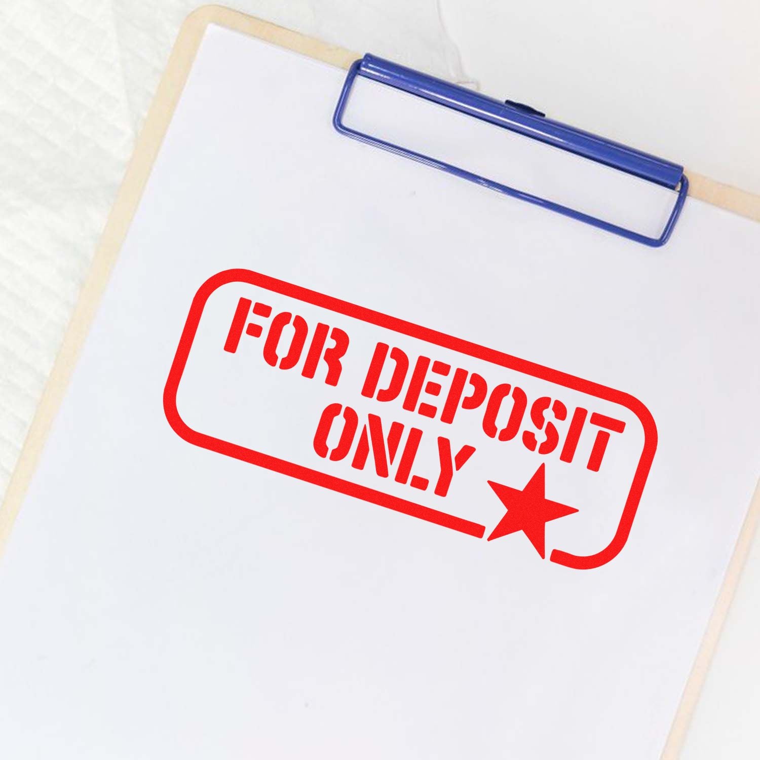 Red FOR DEPOSIT ONLY stamp on a white clipboard with blue clip, showing a bank seal design.