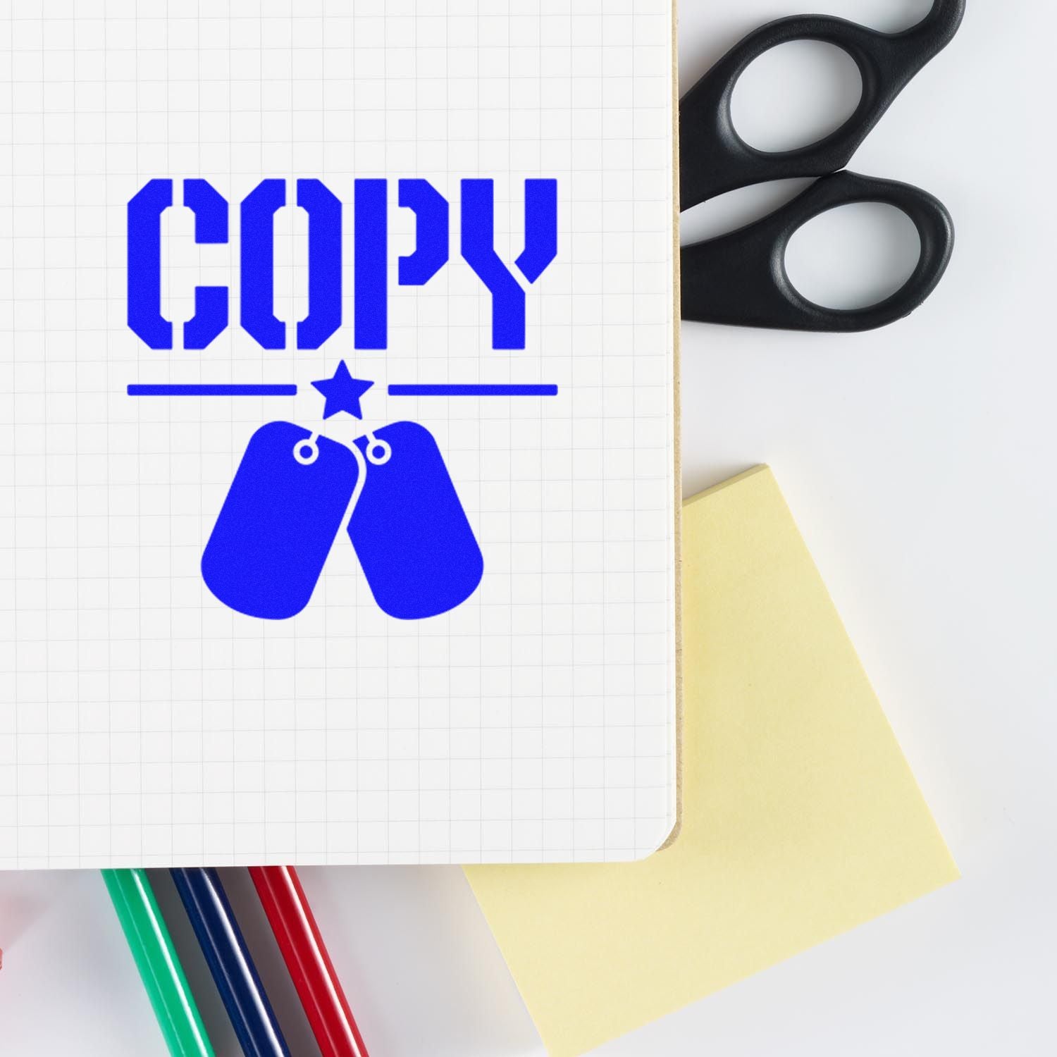Blue COPY stamp with dog tag seal icon on grid paper, with black stamp handles and yellow sticky note.