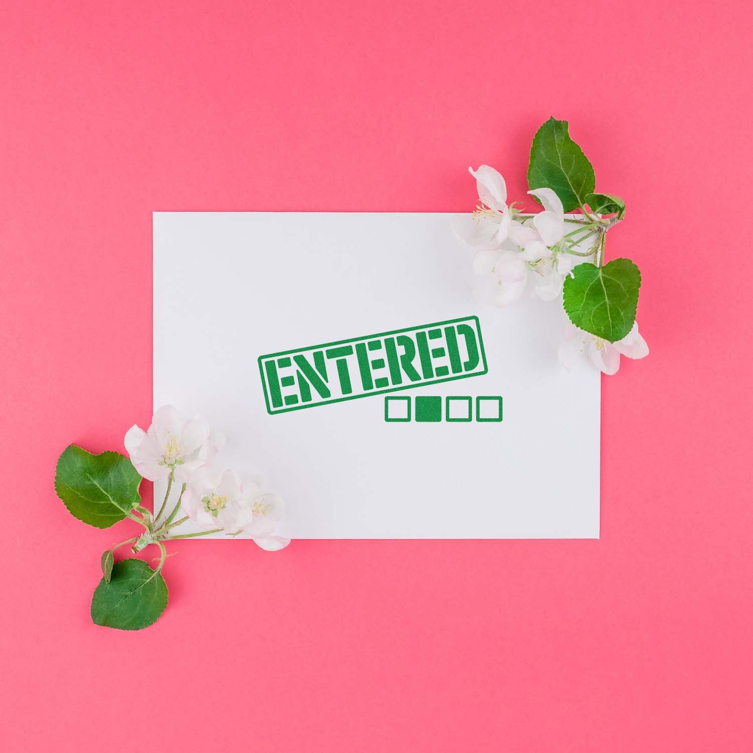 Green ENTERED rubber stamp seal on white card, framed by white blossoms and green leaves against a bright pink background.