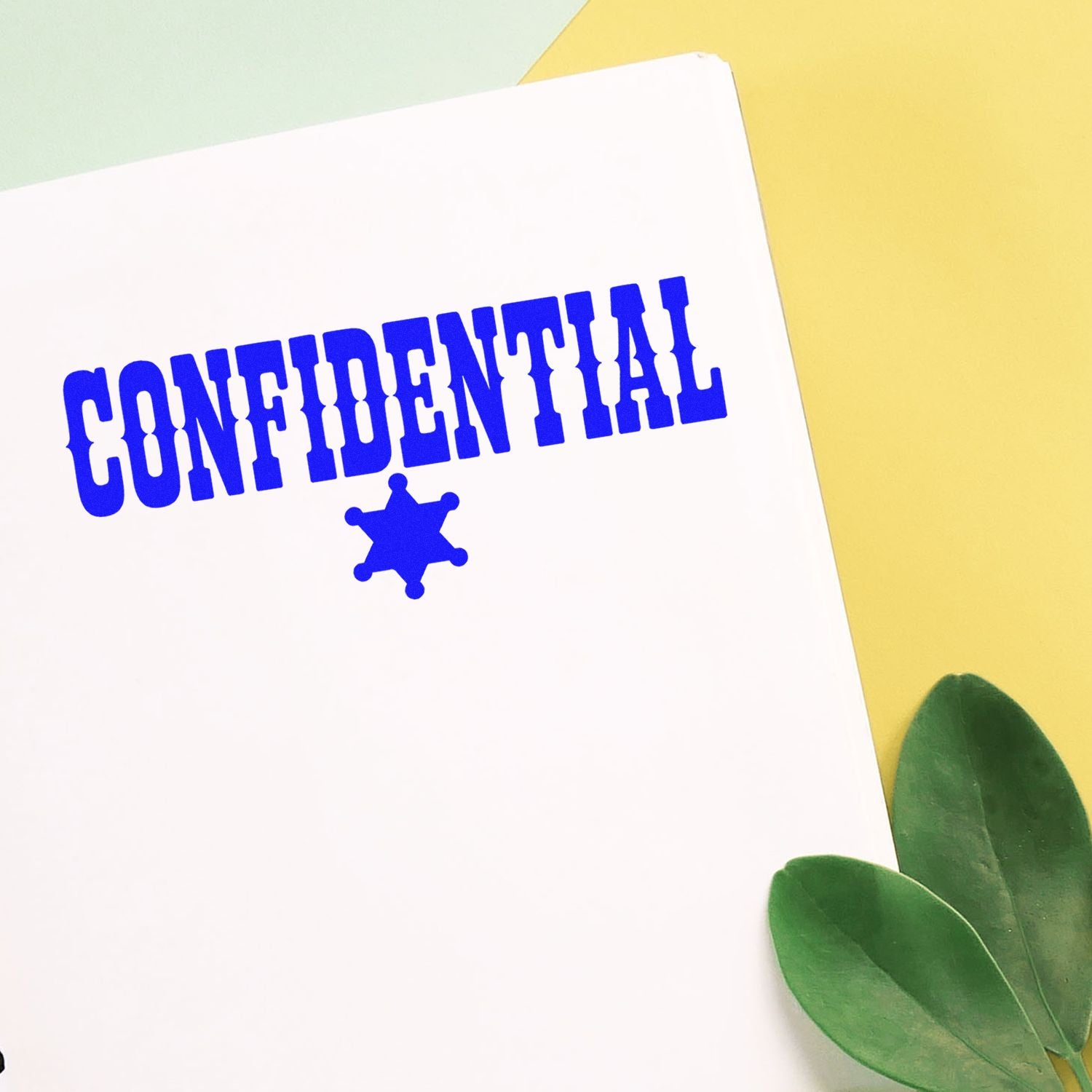 White paper with blue CONFIDENTIAL stamp and star seal on pastel yellow background with green leaves.