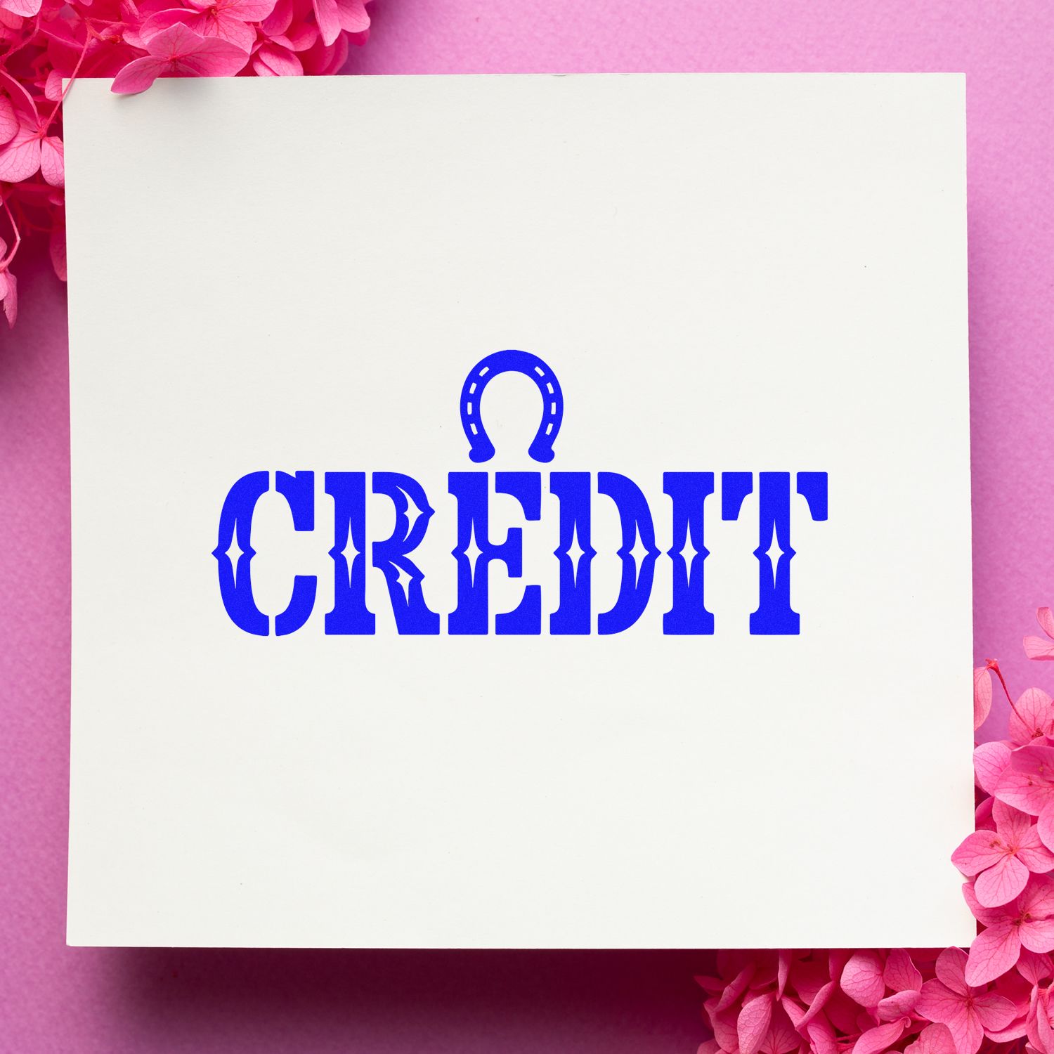 White stamp and seal card with bold blue CREDIT text and horseshoe icon on a pink floral background.