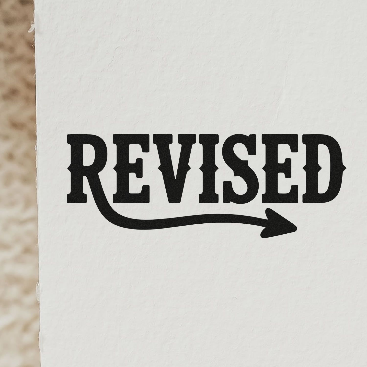 Black REVISED approval stamp and arrow seal on white paper.